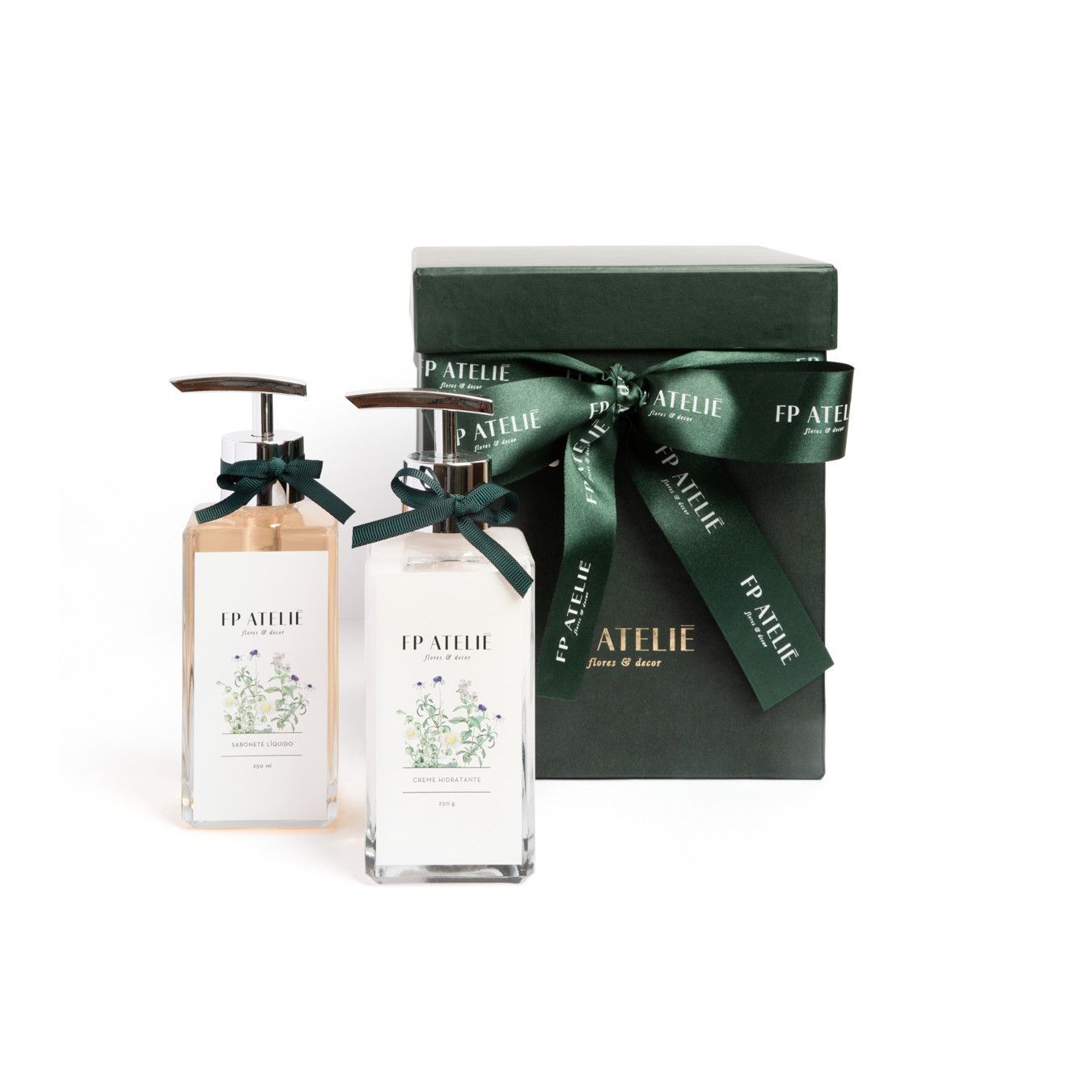 Caixa de presente verde com fita ao lado de dois pequenos frascos de perfume sobre um fundo branco.