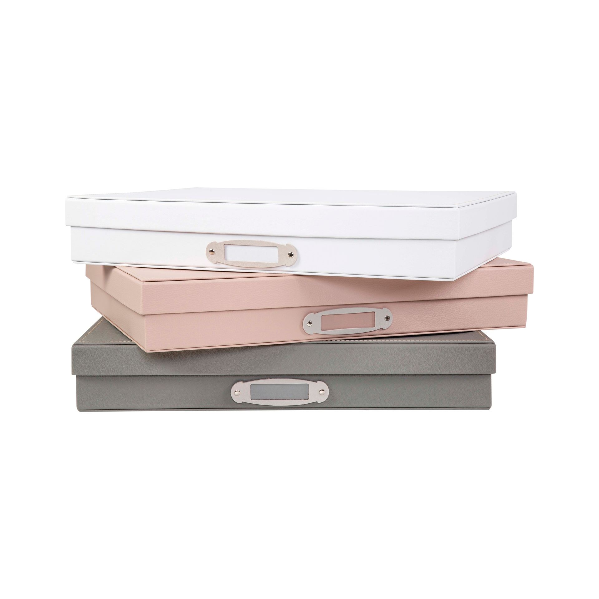 Caixas organizadoras empilháveis em tons pastel branco, rosa e cinza com fechos prateados.