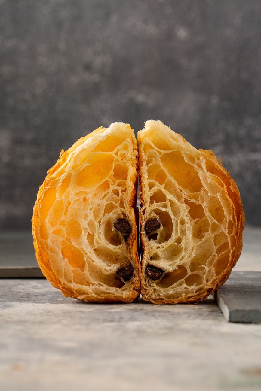 Uma laranja descascada, aberta sobre uma mesa, revelando gomos e sementes de um laranja brilhante.