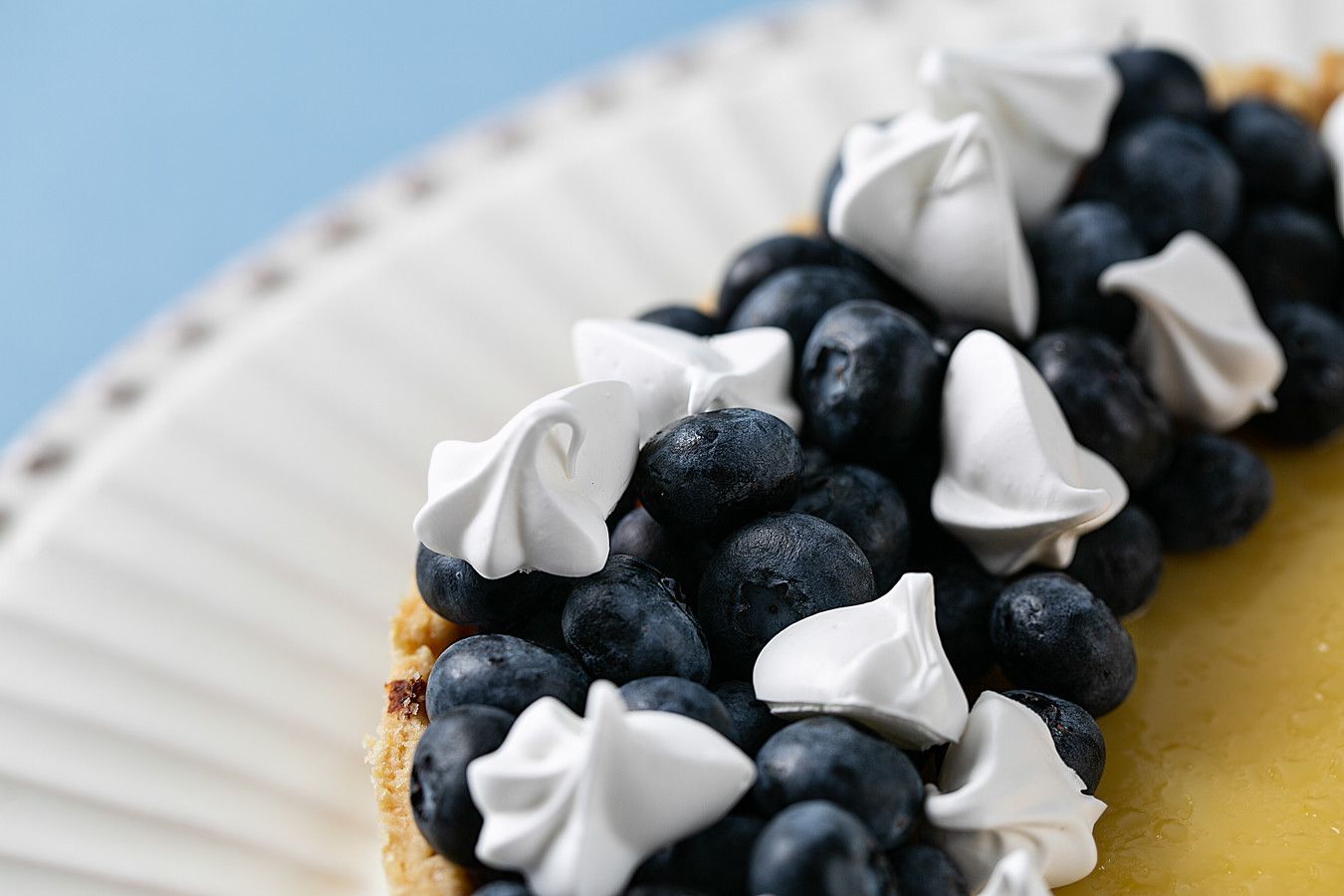 Tarte de mirtilo com cobertura de merengue branco em um prato branco.