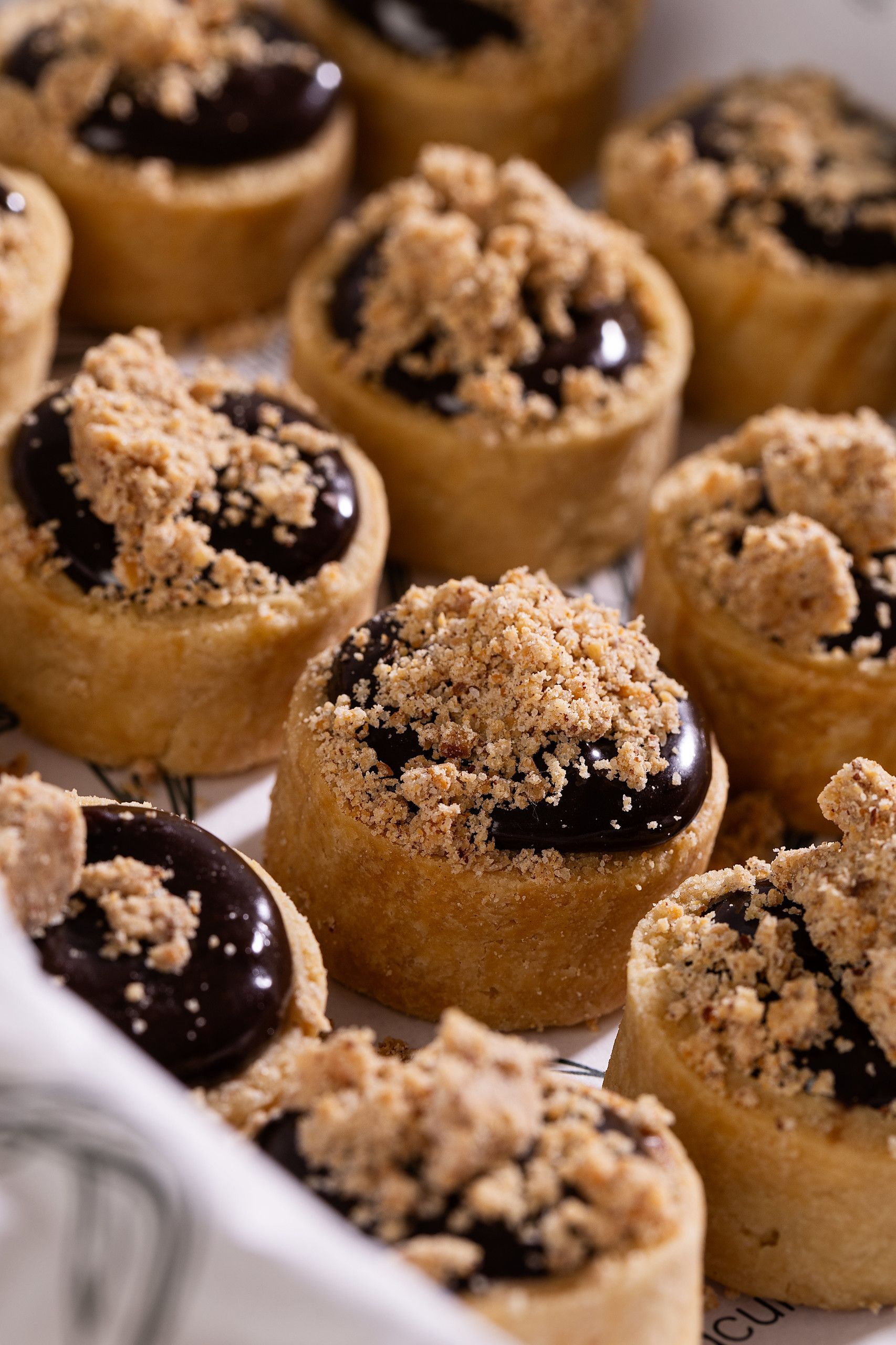Tarteletes de chocolate cobertas com farofa crocante em uma bandeja