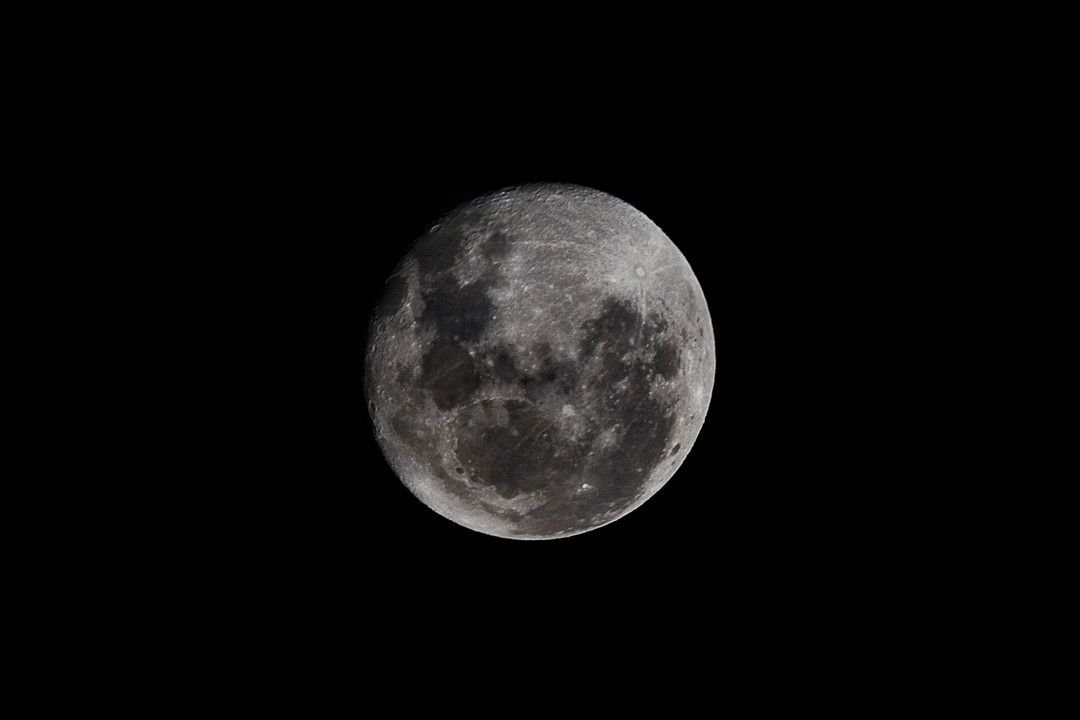 Lua cheia cinzenta contra um céu noturno escuro