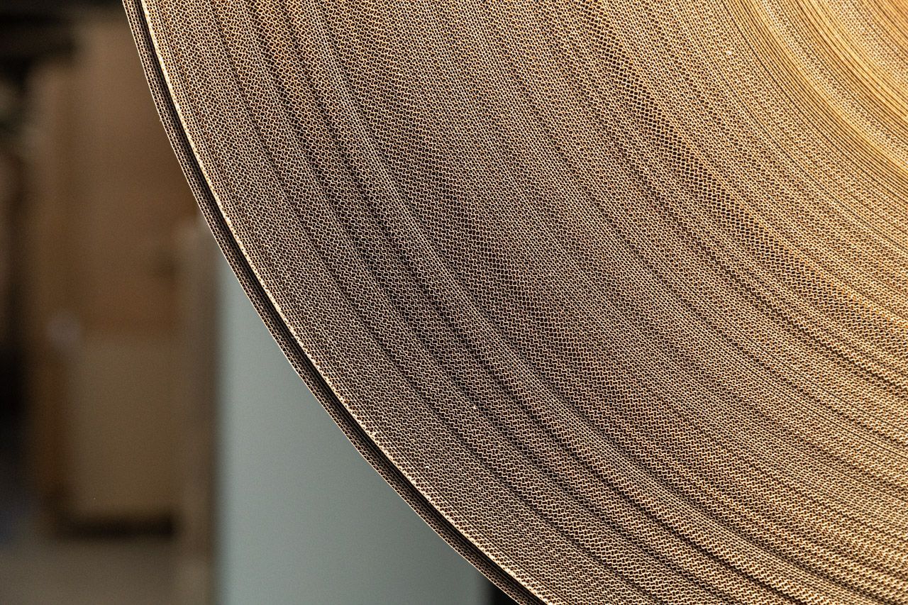 Detalhe da aba de um chapéu de palha trançada com borda marrom escura e padrão texturizado.
