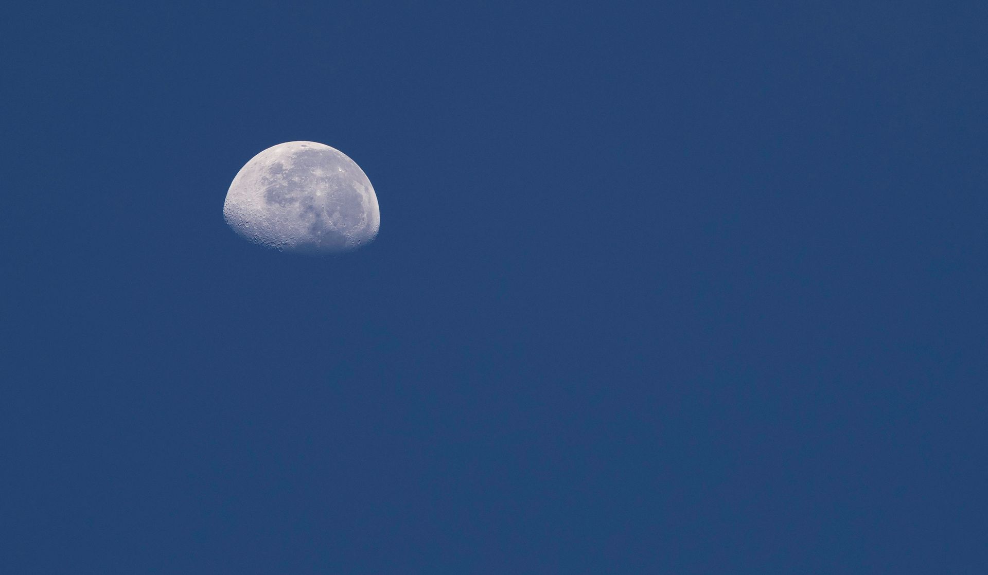 Lua parcialmente visível em um céu azul claro.