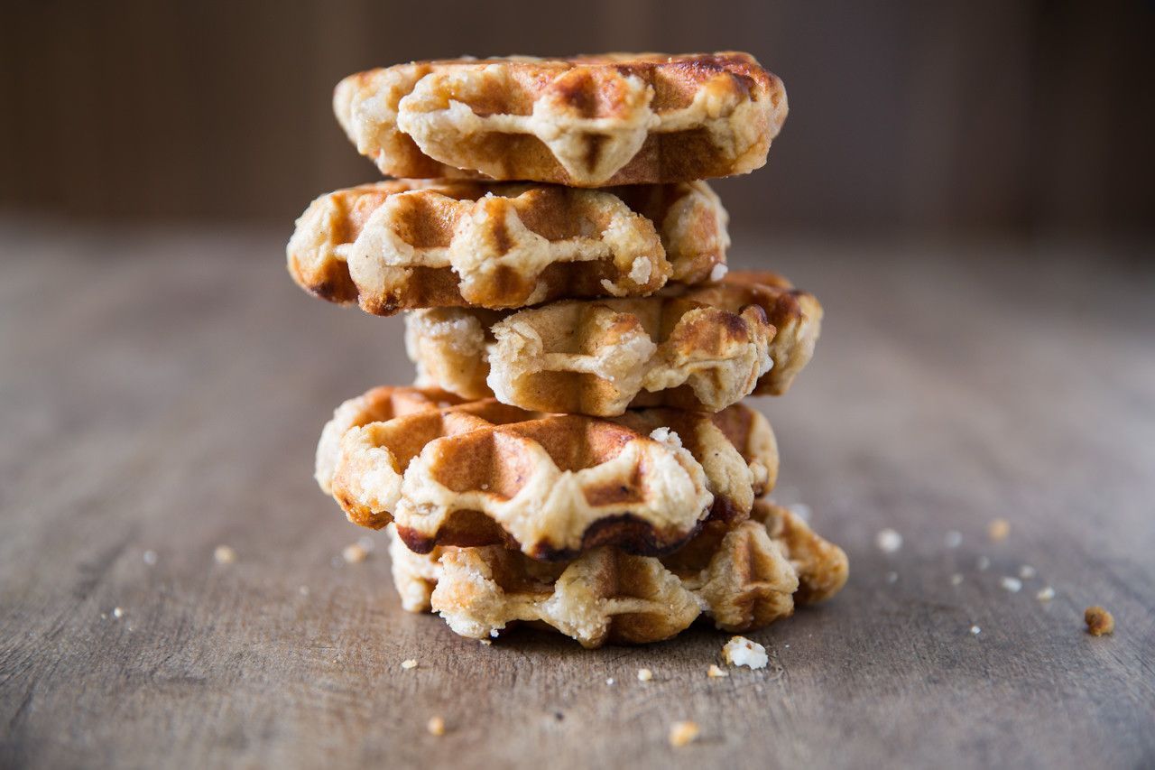 Pilha de waffles dourados sobre uma superfície rústica de madeira.