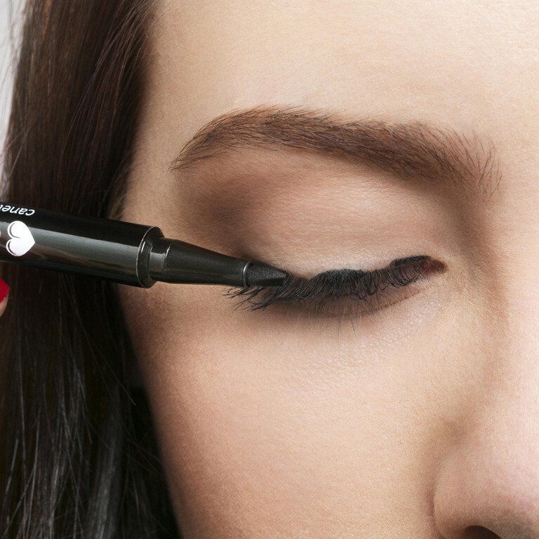 Lápis delineador preto aplicado em olho fechado com cílios escuros.