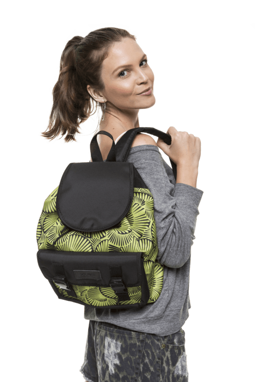 Mulher usando uma mochila preta e verde, olhando por cima do ombro contra um fundo branco.