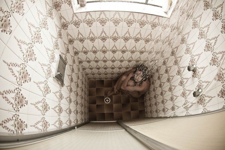 Vista aérea de uma escadaria revestida de azulejos com uma pessoa deitada nos degraus abaixo.