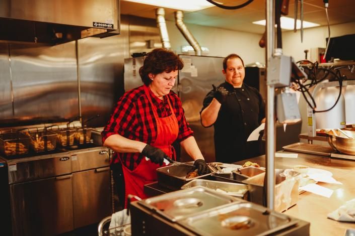 Two chefs preparing food in a stainless steel restaurant kitchen