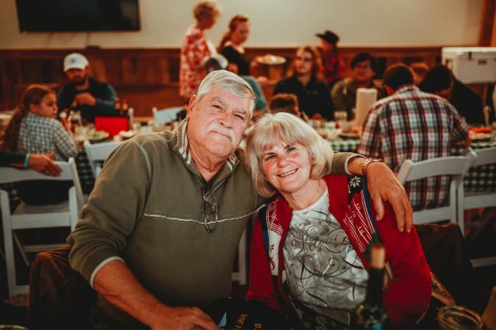 Smiling couple seated together at a table in a warmly lit restaurant or event hall