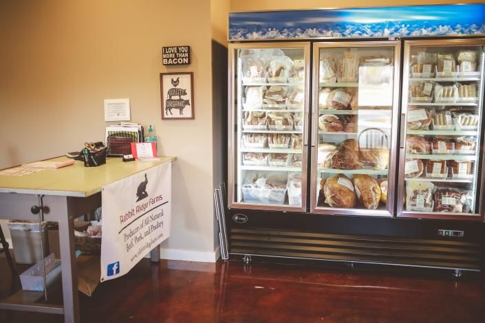 Bakery display case with pastries and a small counter in a warmly lit shop