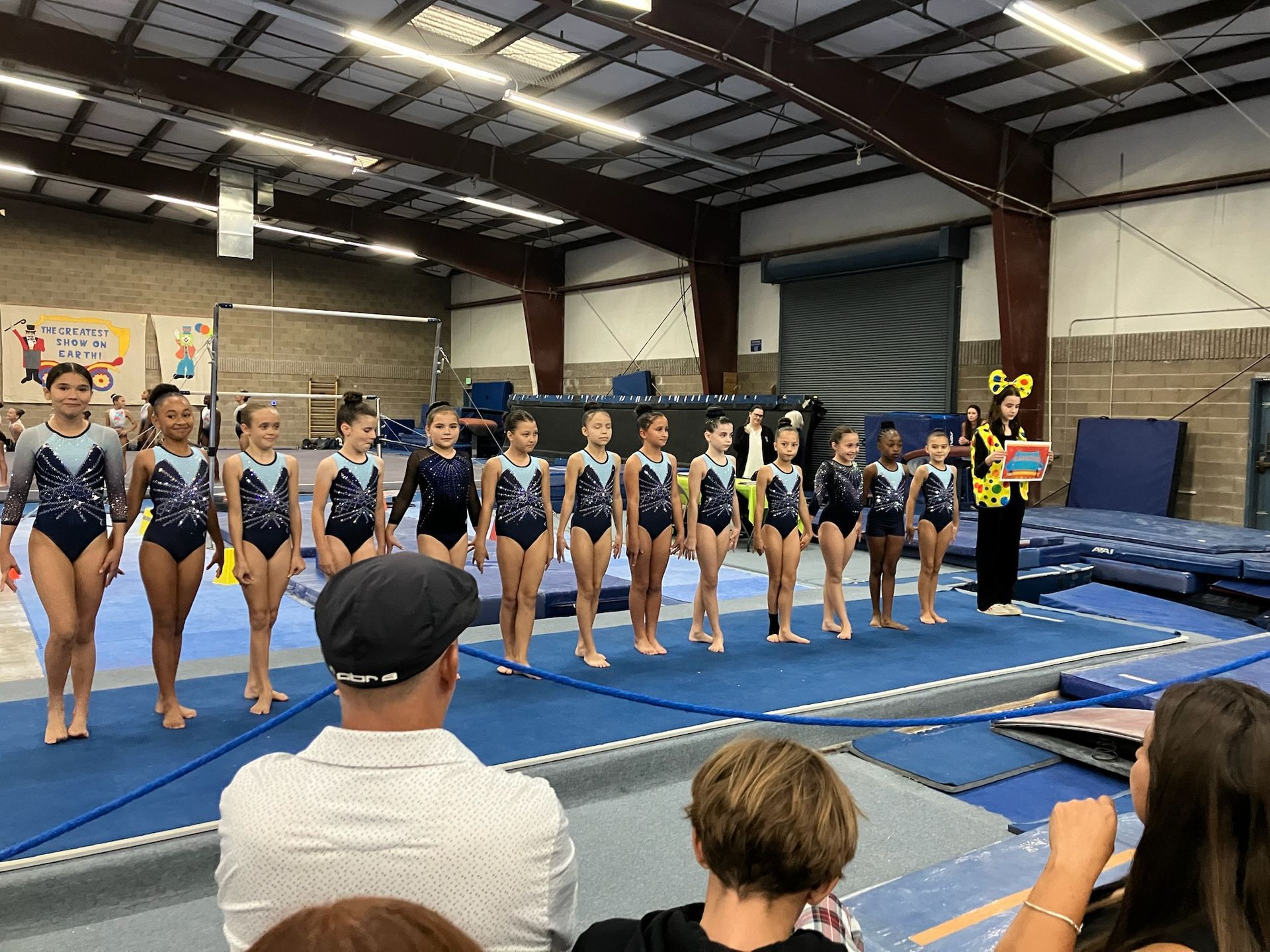 A group of female gymnasts are holding hands in a row.