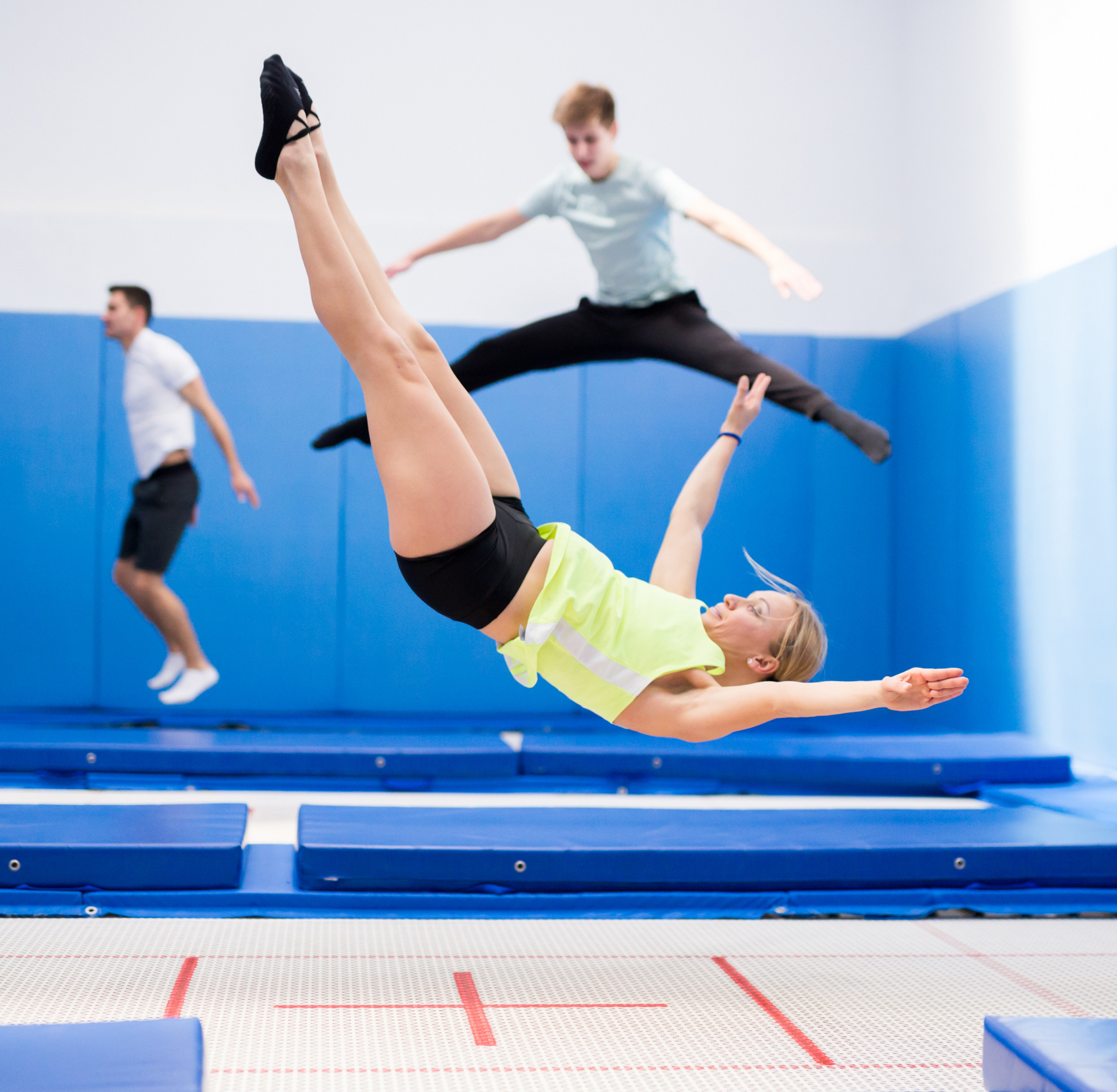 A gymnast is sitting on a balance beam covered in chalk.