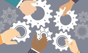 A group of people are working together to put gears together.