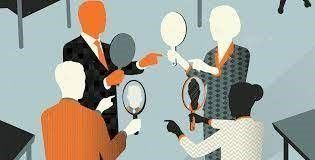 A group of people are looking at themselves in mirrors.