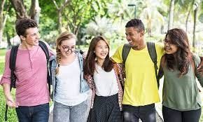 A group of young people are walking together in a park.