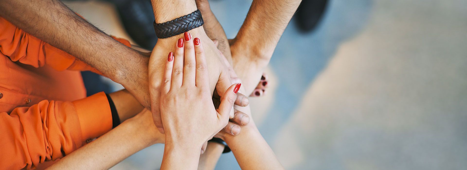 A group of people are putting their hands together in a circle.