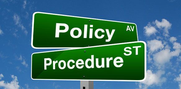 A green street sign that says policy and procedure