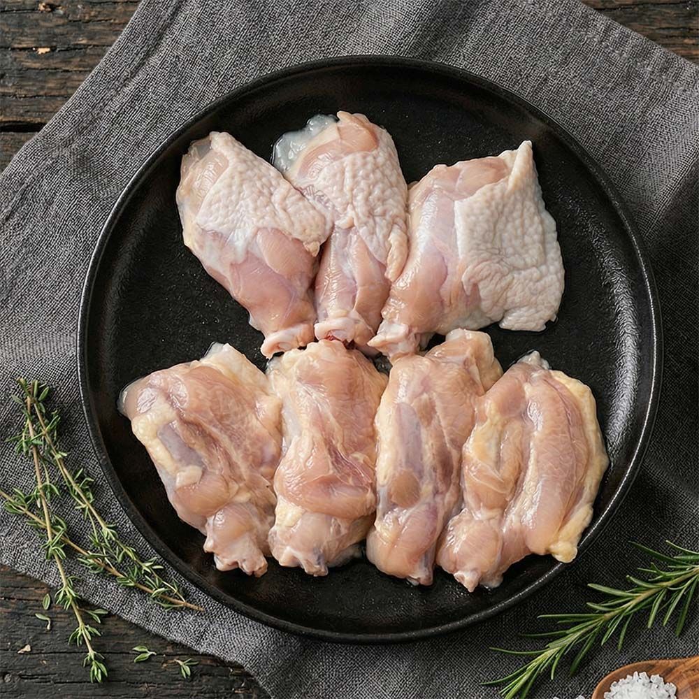 Fried chicken wings in white bowl, garnished with herbs.