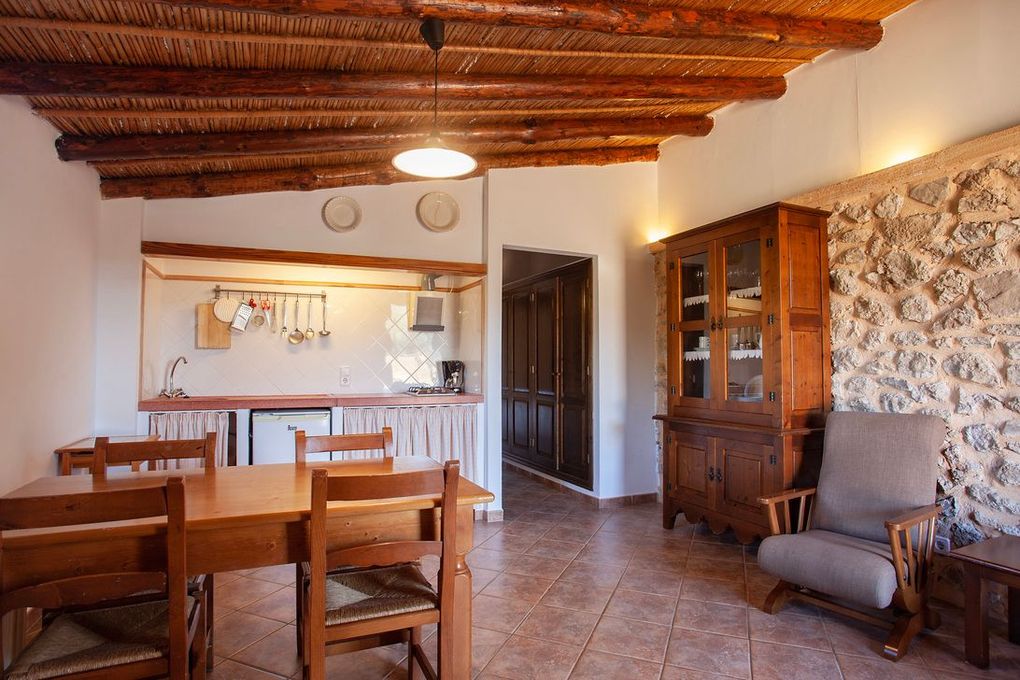 Una sala de estar con una mesa y sillas y una pared de piedra.