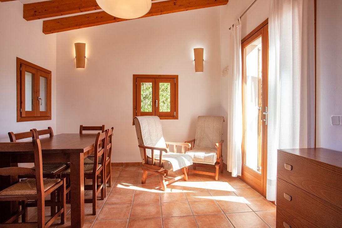 Una sala de estar con una mesa y sillas y una cómoda.