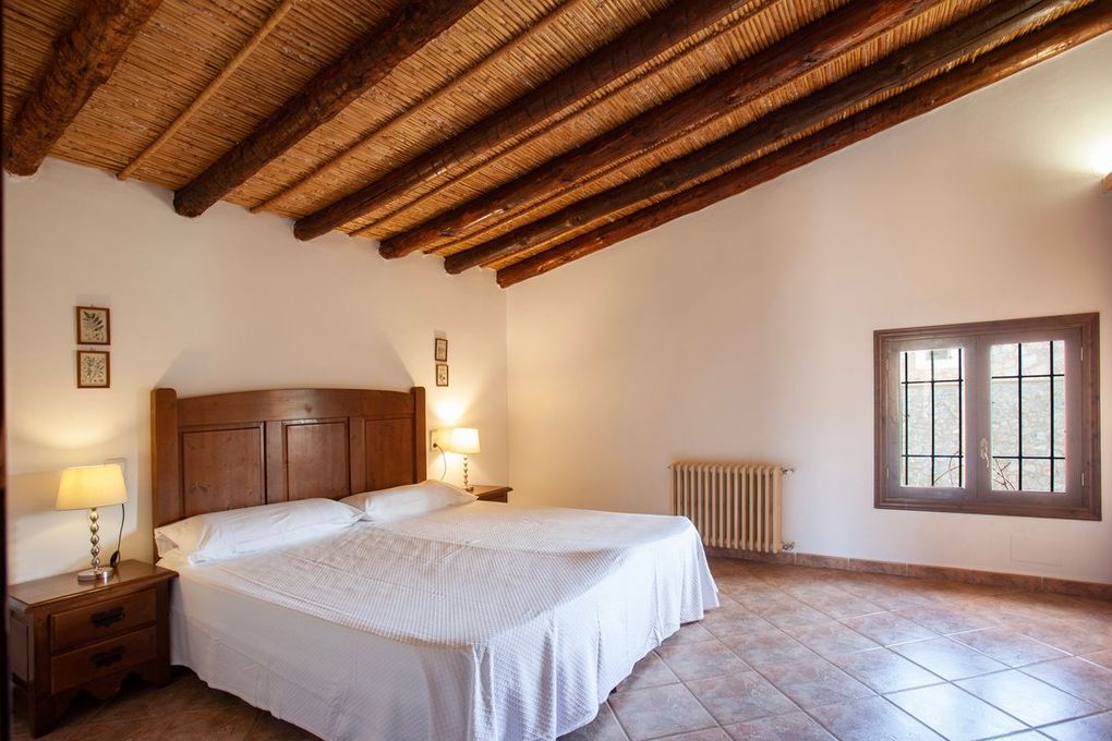 Un dormitorio con dos camas y techo de paja.