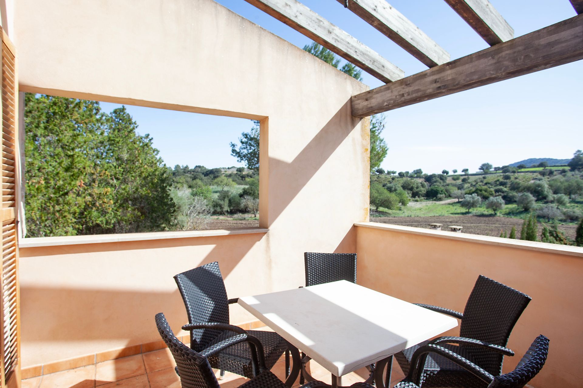 A balcony with a table and chairs and a large window