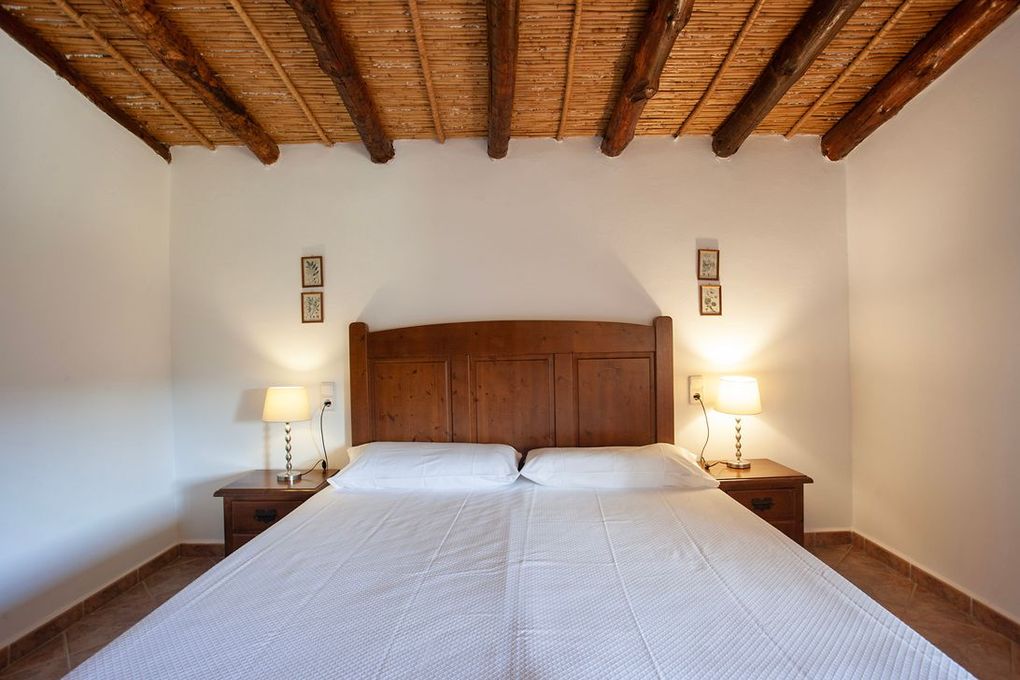 Un dormitorio con dos camas y techo de madera.