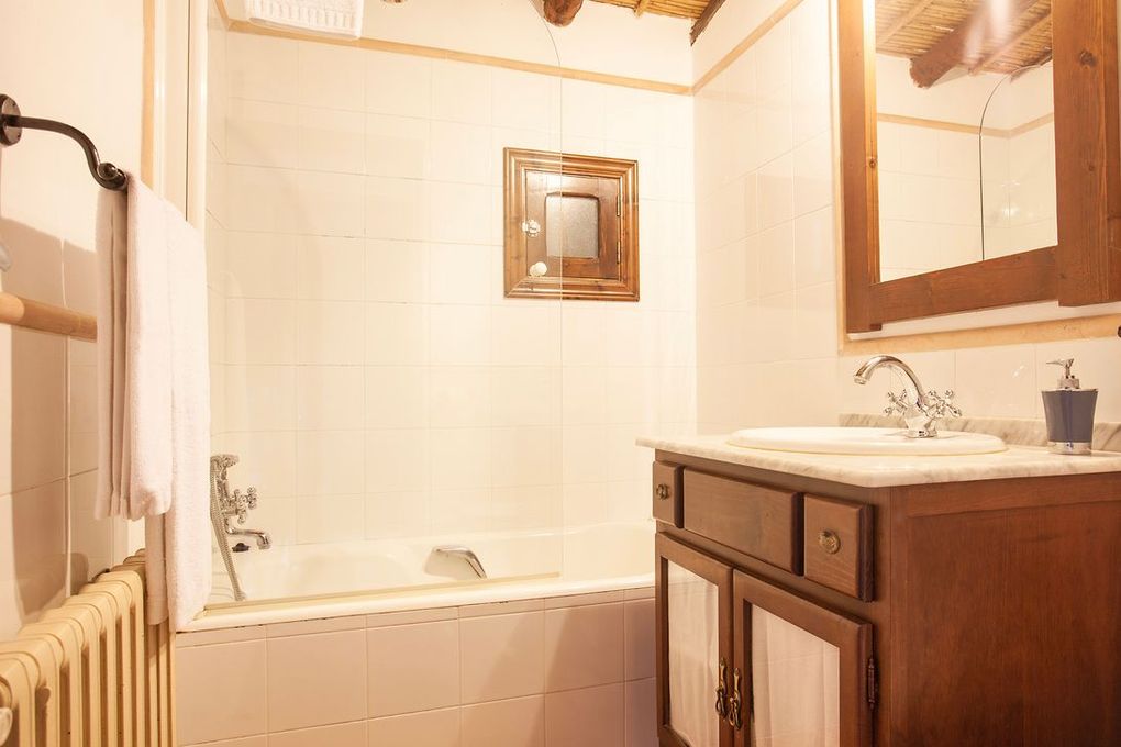 Un baño con lavabo, bañera, espejo y radiador.