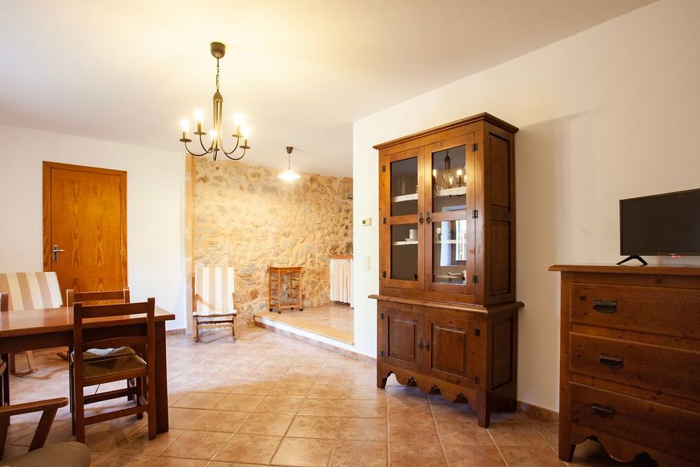 Una sala de estar con mesa, sillas, tocador y televisión.