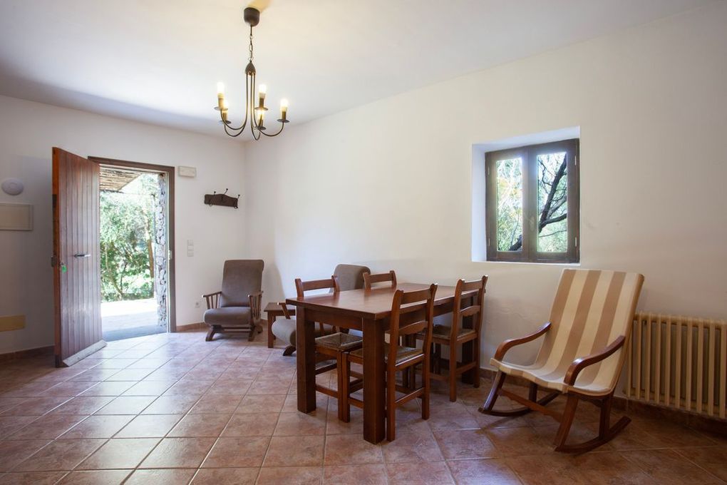 Una sala de estar con una mesa y sillas y una ventana.