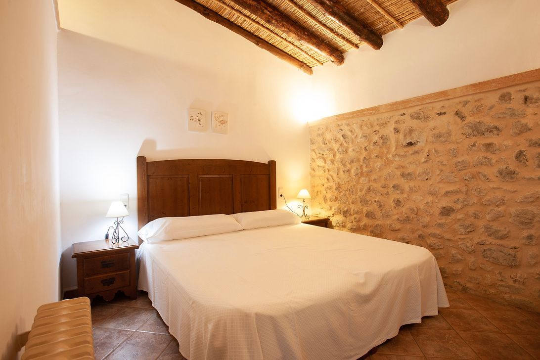 Ein Schlafzimmer mit einem großen Bett und einer Steinwand