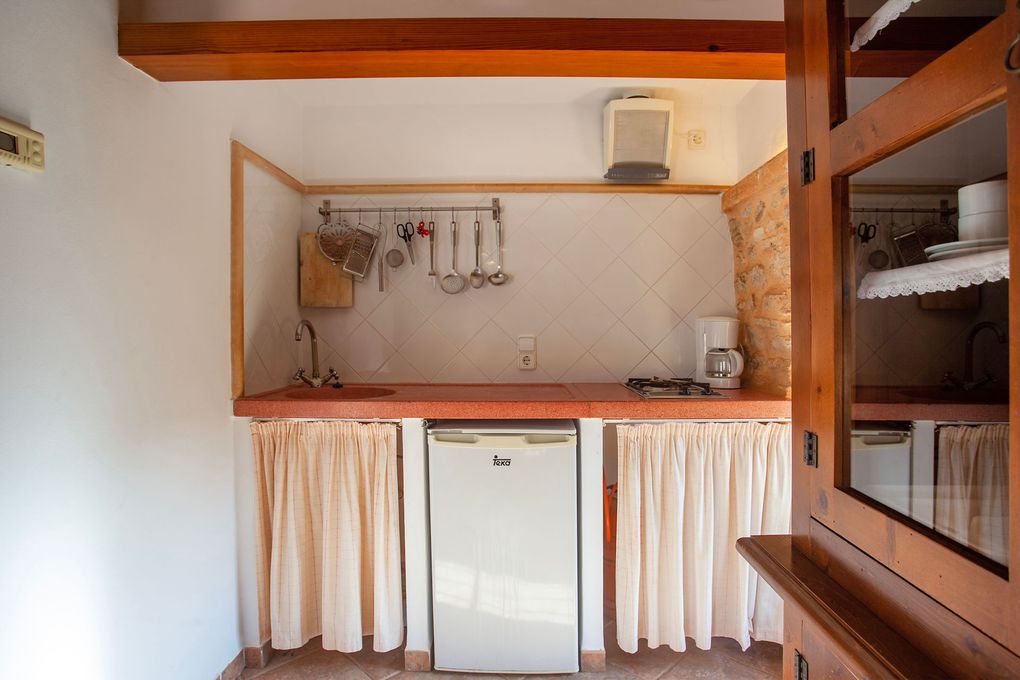 Una pequeña cocina con frigorífico y fregadero.