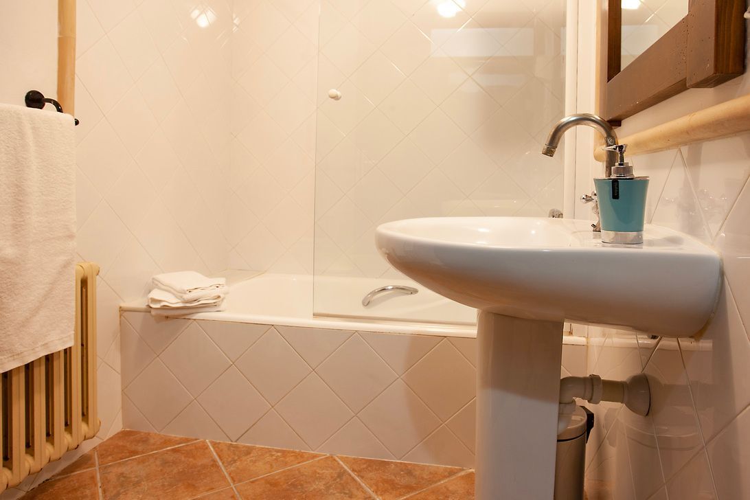Ein Badezimmer mit Waschbecken, Badewanne und Spiegel.