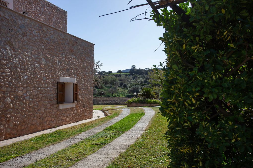 Un edificio de piedra con un camino de entrada que conduce a él.