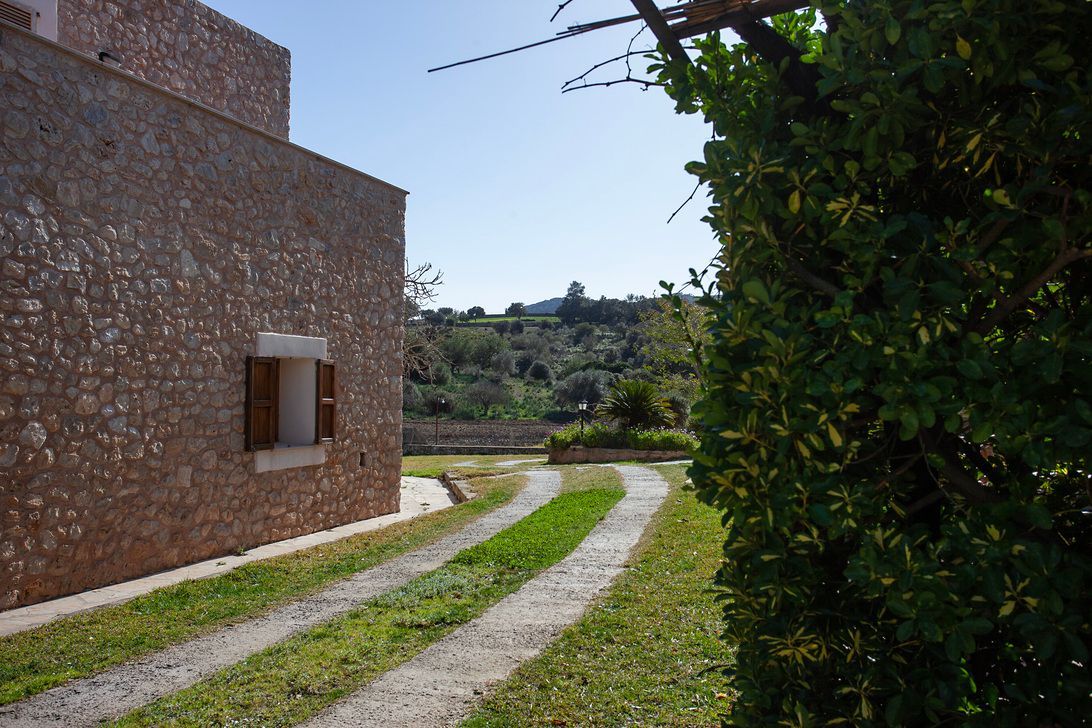 A stone building with a driveway leading to it