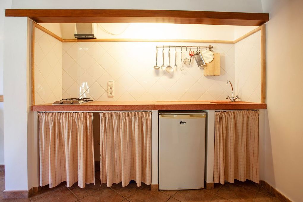Una pequeña cocina con estufa y refrigerador.