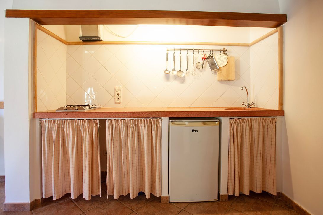 Eine kleine Küche mit Herd und Kühlschrank