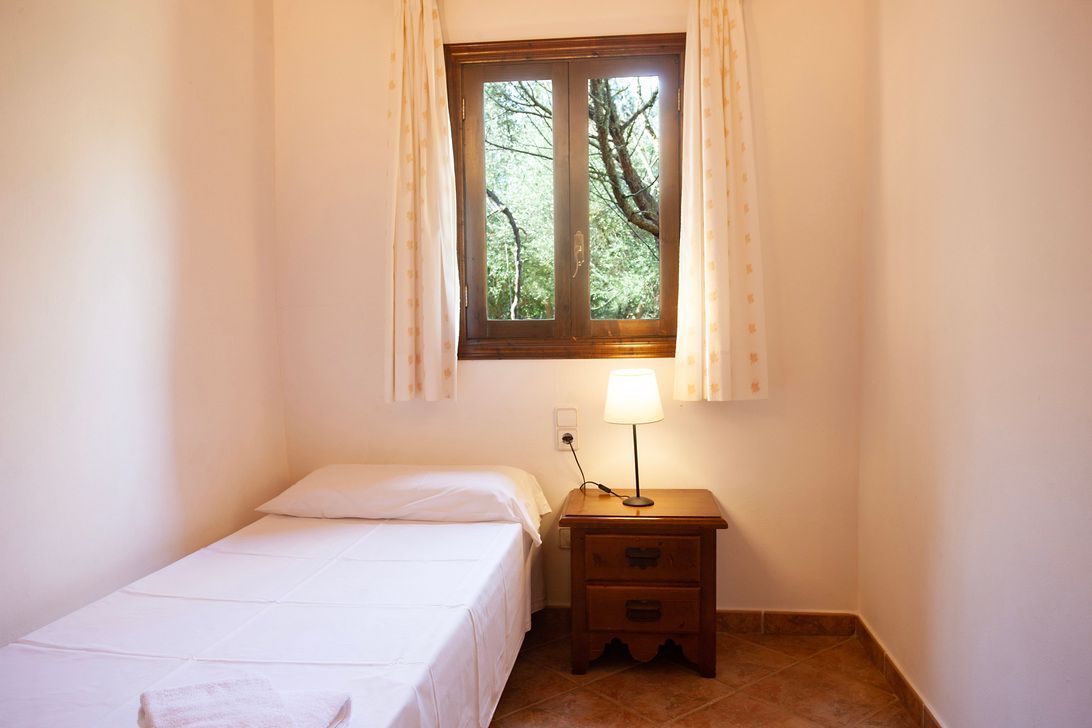 A bedroom with a single bed and a window