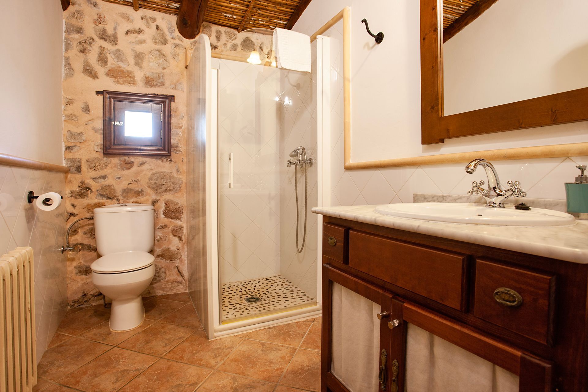 A bathroom with a toilet , sink and shower.