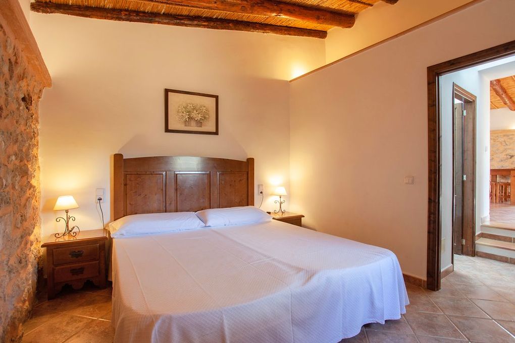 Un dormitorio con una cama grande y dos mesitas de noche.