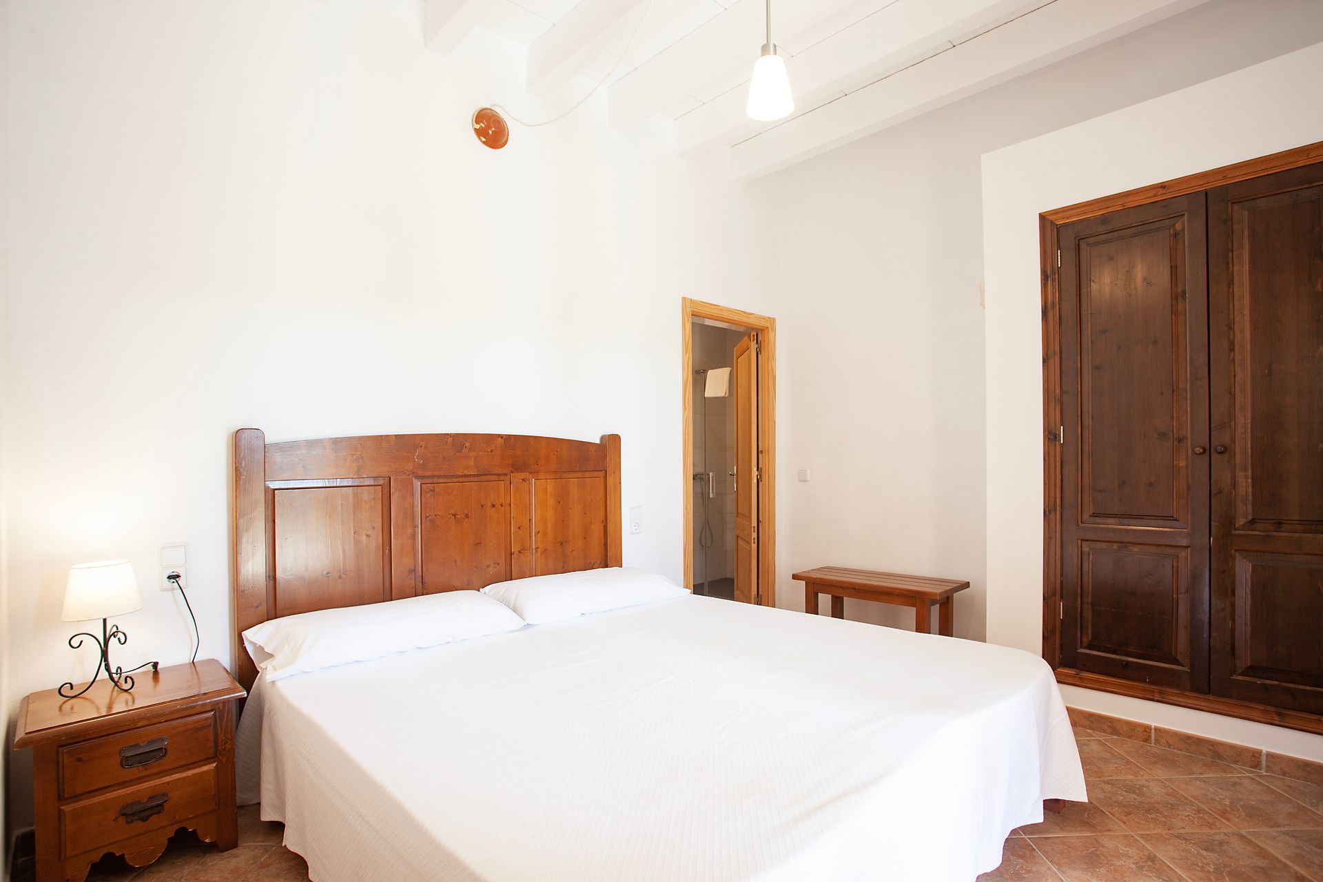 A bedroom with a large bed and a nightstand