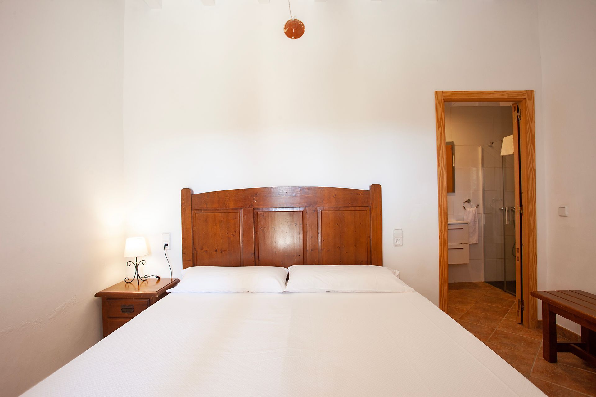 A bedroom with a large bed and a wooden headboard