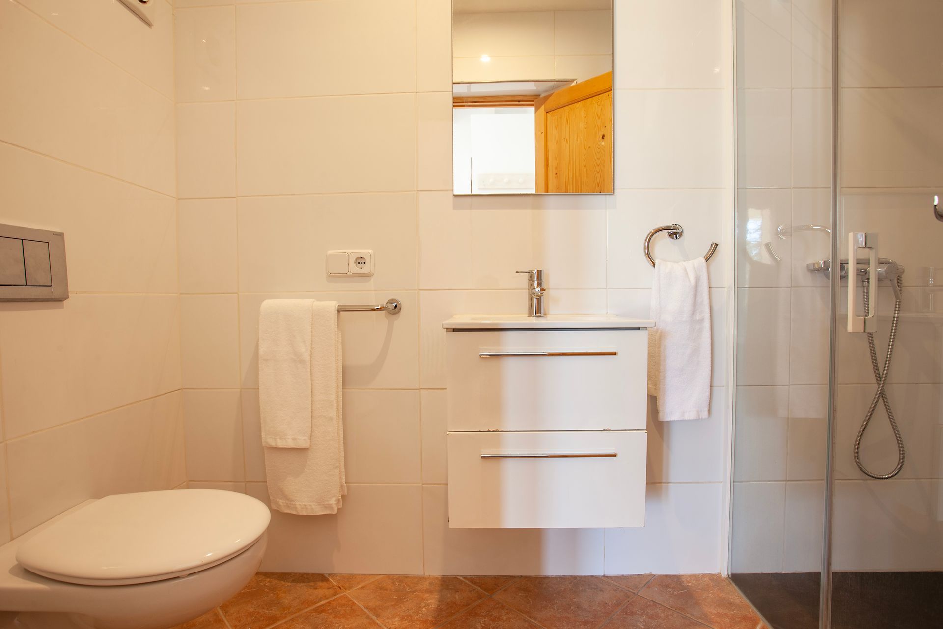 A bathroom with a toilet , sink and shower.