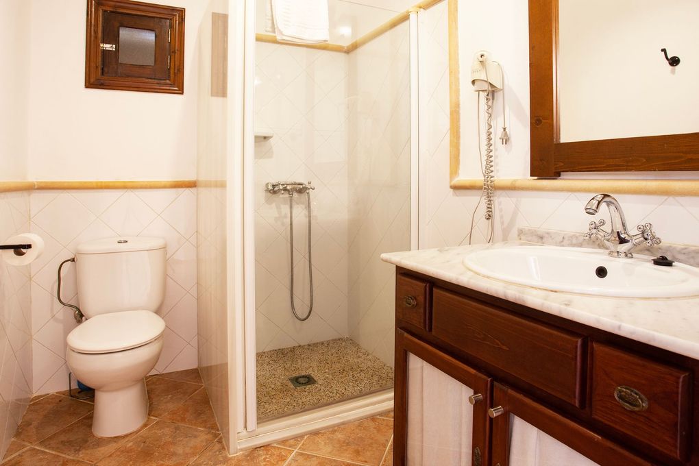 Un baño con inodoro, lavabo y ducha.