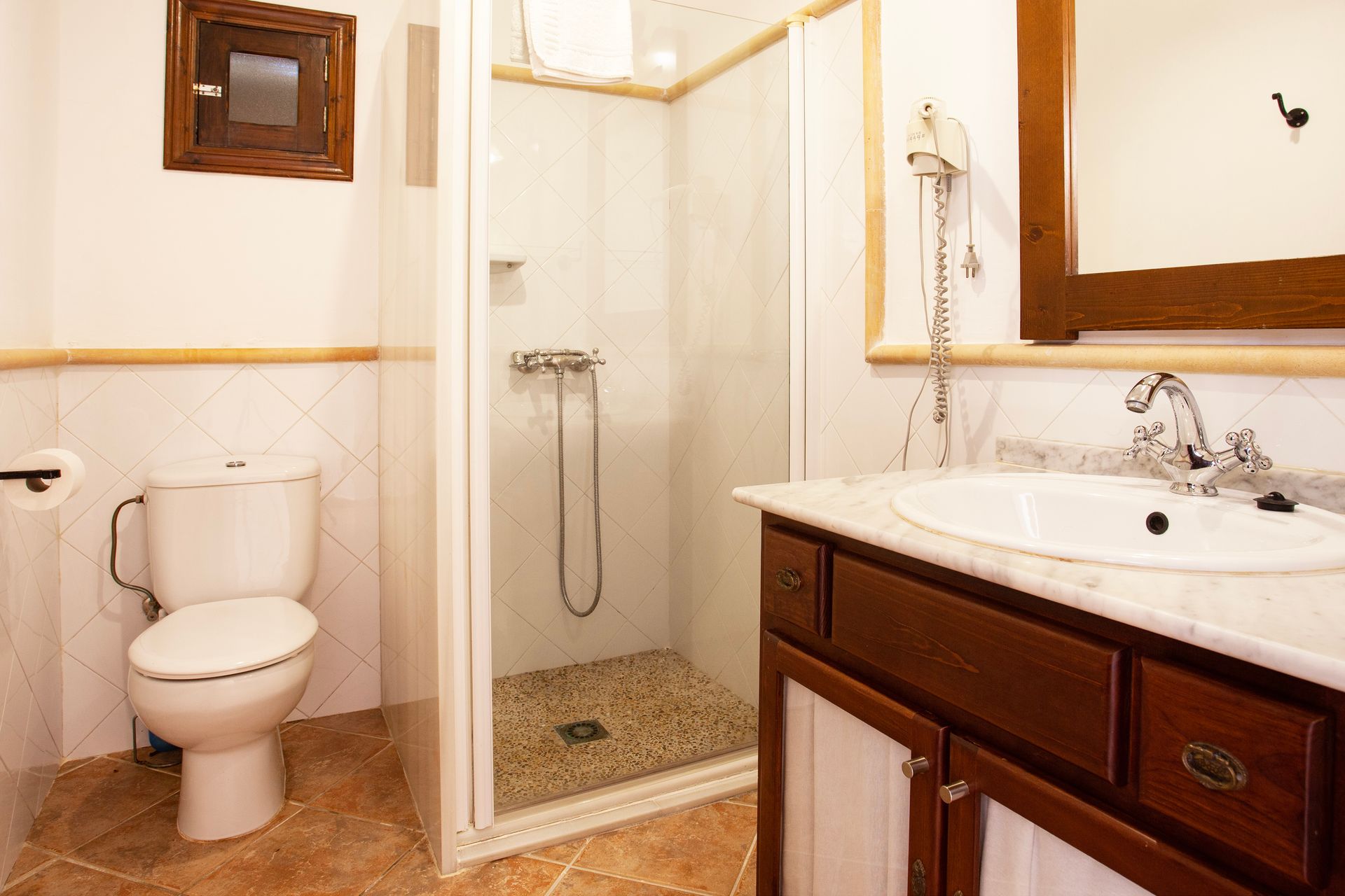 A bathroom with a toilet , sink and shower.