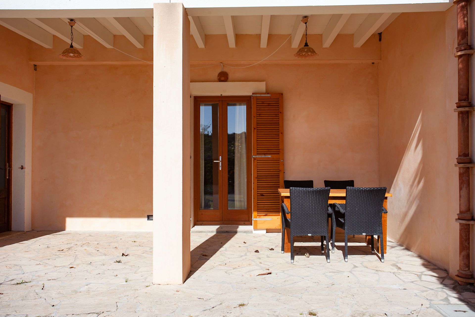 A patio with a table and chairs under a roof