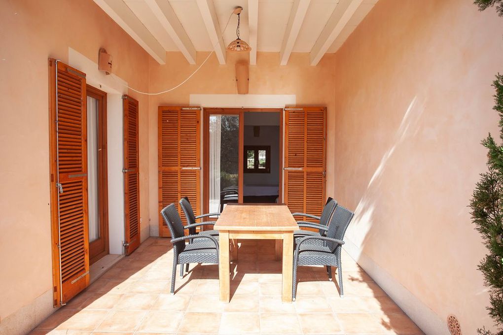 Un patio con una mesa y sillas.