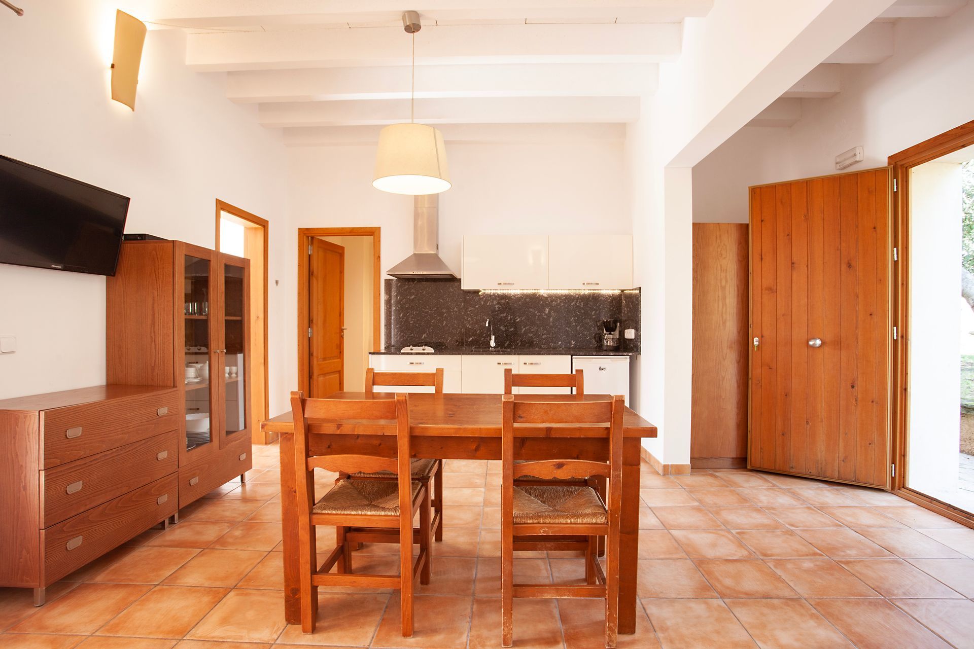 A living room with a table and chairs and a kitchen
