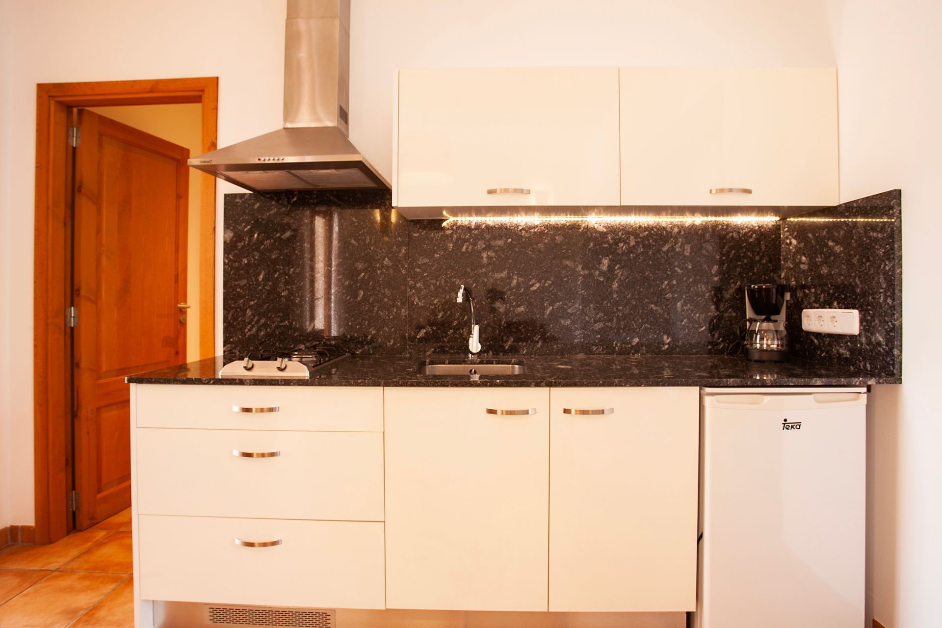 A kitchen with white cabinets and black granite counter tops